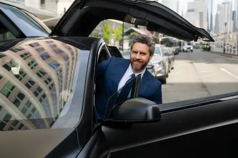 Car service Atlanta chauffeur is getting in the car for hourly as directed limo service