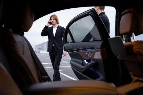 Executive getting in a car service Atlanta luxury sedan for Long-Distance Trips